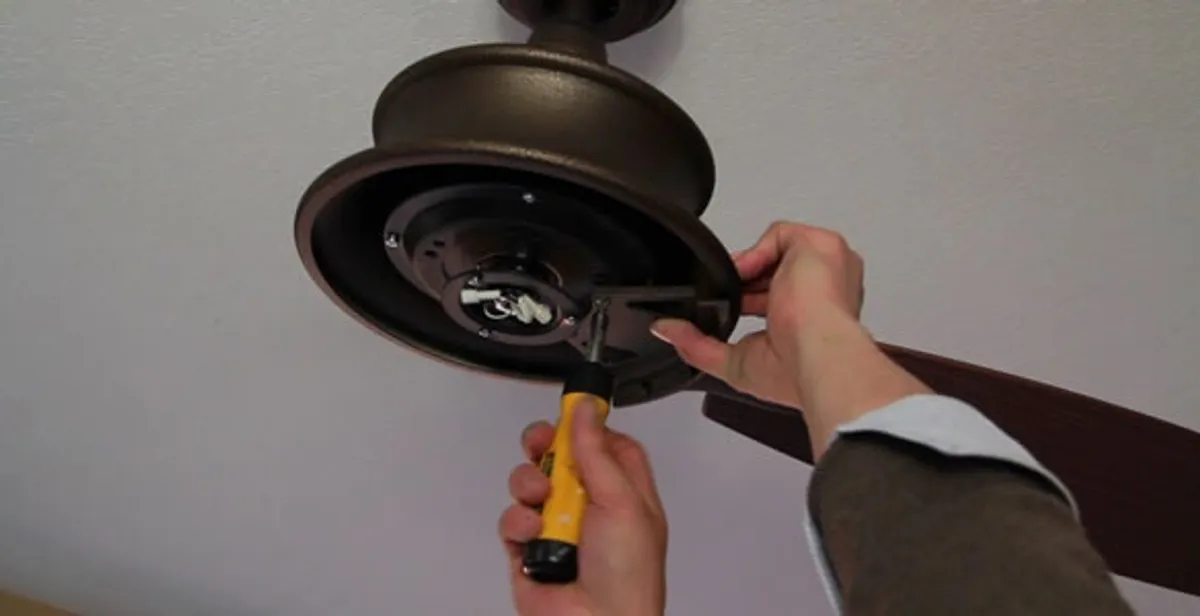 Electrician installing ceiling fan mounting bracket and fixture in Des Moines, IA