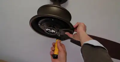 Electrician installing ceiling fan mounting bracket and fixture in Des Moines, IA
