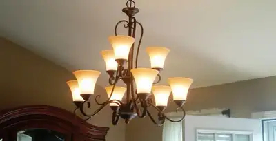 Classic ceiling chandelier installation with warm lighting in Des Moines, IA