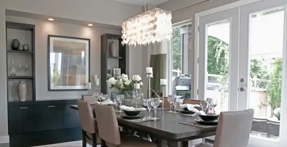 Elegant dining room chandelier installation above table in Des Moines, IA