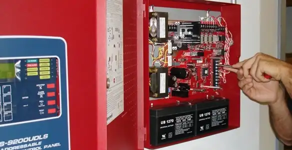 fire alarm installation service showing technician configuring fire alarm control panel in Des Moines, IA