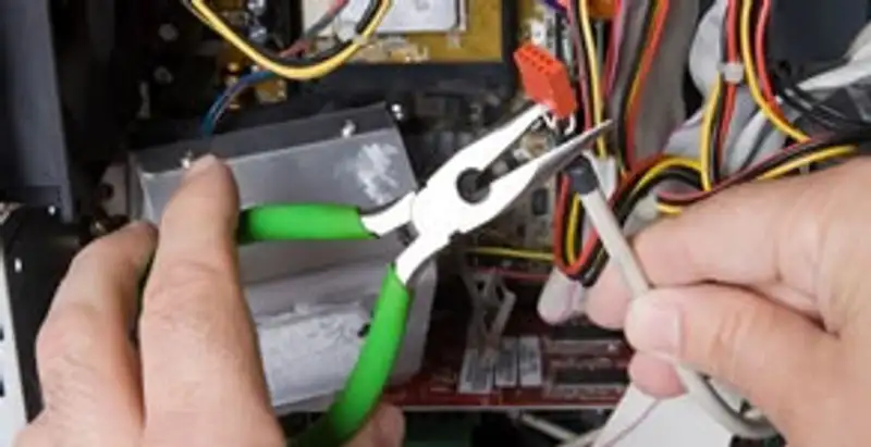 Licensed electrical contractor performing electrical repair with tools in Norwalk, IA