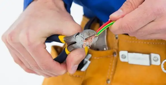 licensed electrician securing electrical wiring with professional tools during service work in Des Moines, IA