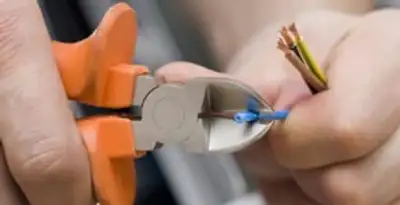 licensed electrician performing precise wire cutting and preparation during electrical service in Des Moines, IA