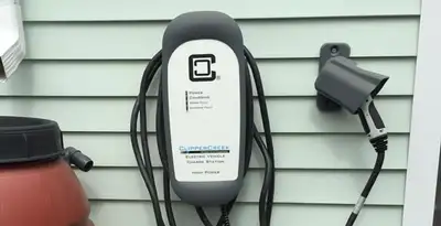 Outdoor electric vehicle charger installation on residential wall in Des Moines, IA